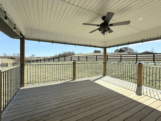 wooden terrace with ceiling fan and fence