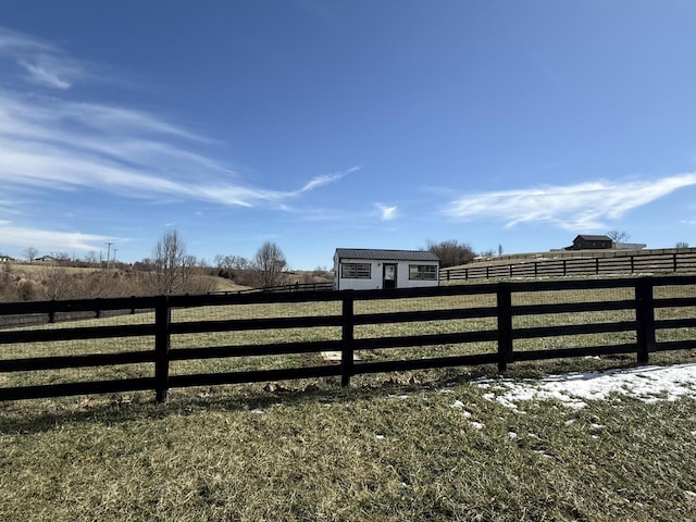 view of gate with fence and a rural view