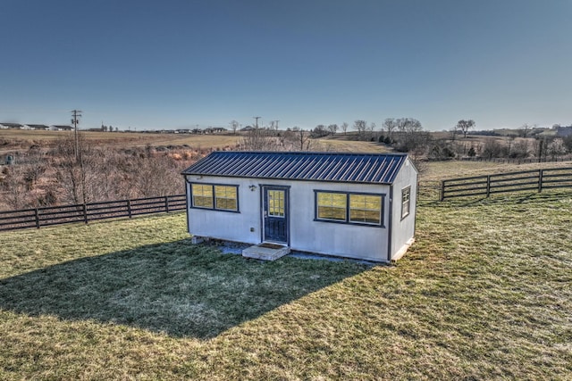 view of outbuilding featuring a rural view and a fenced backyard