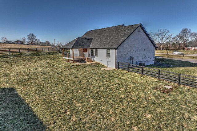 exterior space featuring a yard, a rural view, and fence