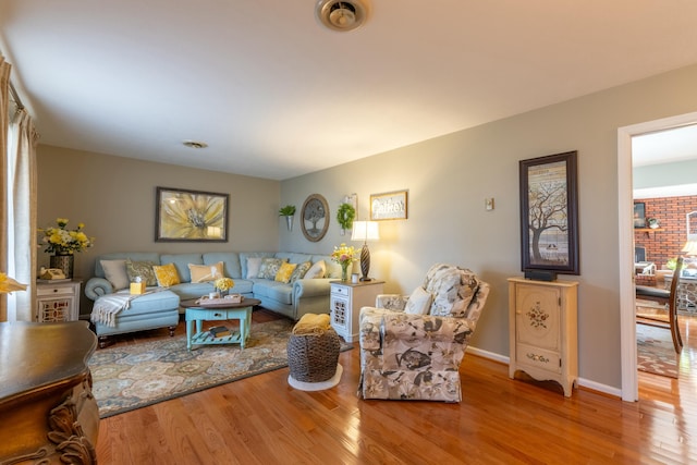 living room featuring wood finished floors, visible vents, and baseboards