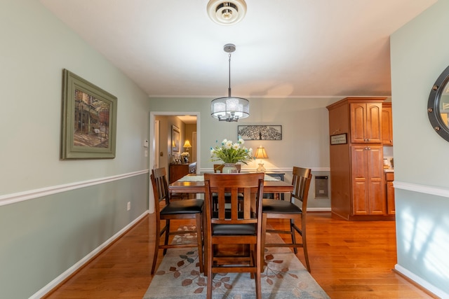 dining area featuring baseboards, a chandelier, and light wood-style floors