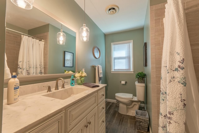 bathroom featuring baseboards, toilet, a shower with curtain, vanity, and wood finish floors