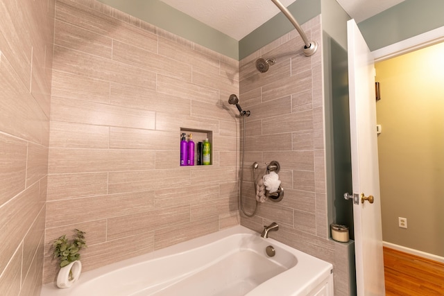 bathroom with shower / bath combination, wood finished floors, and baseboards