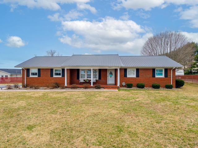 ranch-style home with a front yard, brick siding, and metal roof