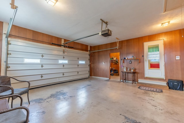 garage with wood walls and a garage door opener