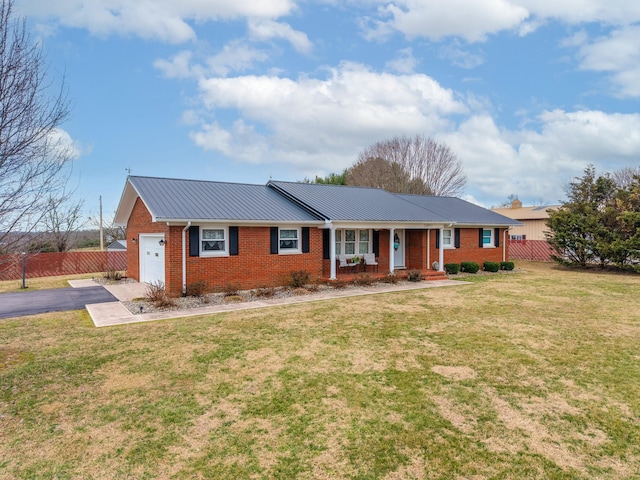 ranch-style home with driveway, brick siding, metal roof, a porch, and a front yard