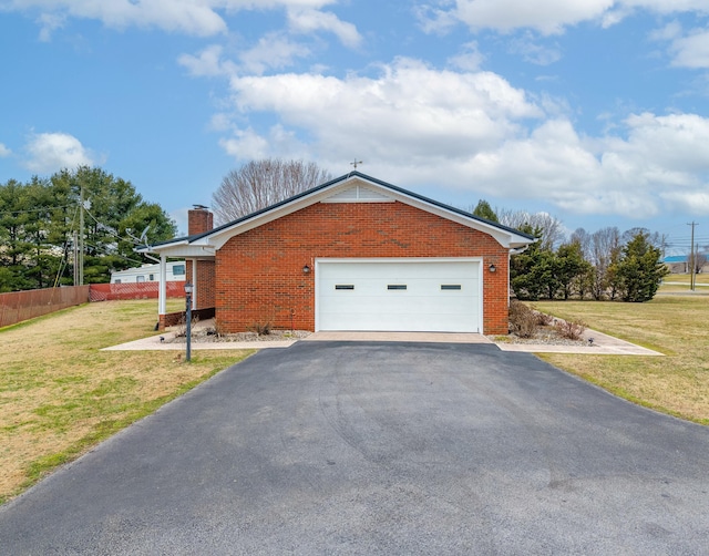 view of side of home featuring a yard, brick siding, a chimney, and fence