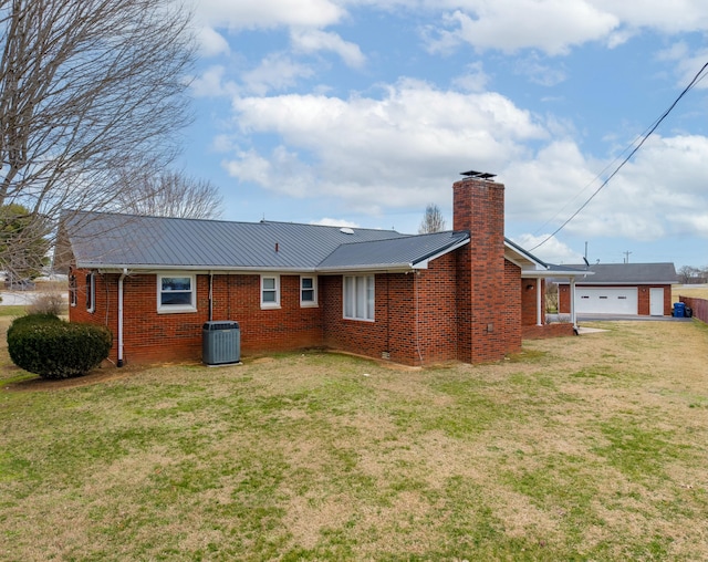 back of property featuring a lawn, a chimney, metal roof, cooling unit, and brick siding