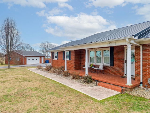 view of front of home featuring metal roof, a porch, brick siding, an outdoor structure, and a front yard