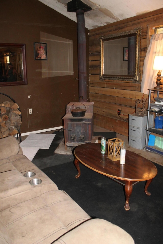 living room featuring a wood stove and wood walls