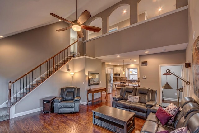 living area with hardwood / wood-style flooring, stairs, baseboards, and a ceiling fan