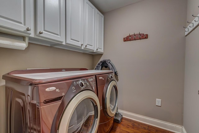 laundry area featuring baseboards, wood finished floors, cabinet space, and washer and dryer