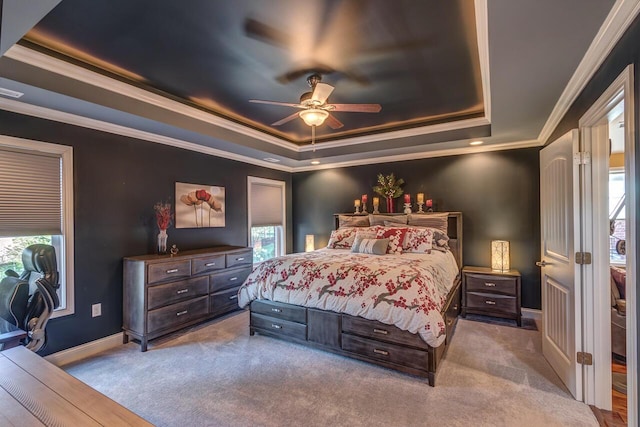 bedroom featuring a tray ceiling, baseboards, multiple windows, and carpet