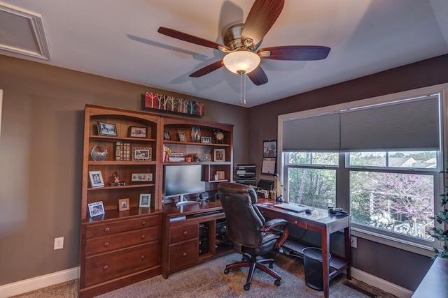 carpeted home office with ceiling fan and baseboards