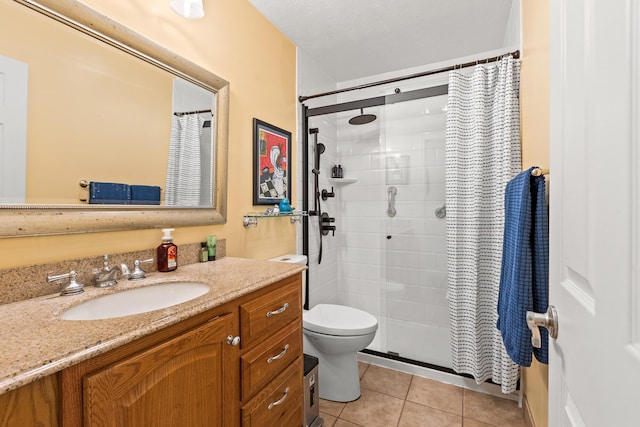 bathroom featuring tile patterned flooring, toilet, vanity, and a shower stall