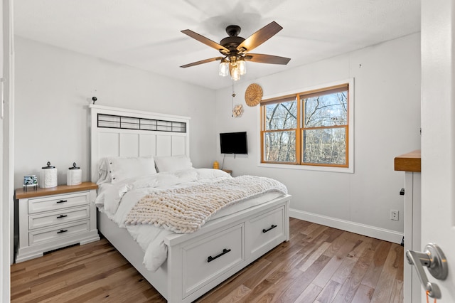 bedroom featuring light wood finished floors, ceiling fan, and baseboards