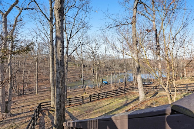 view of yard featuring a water view and fence