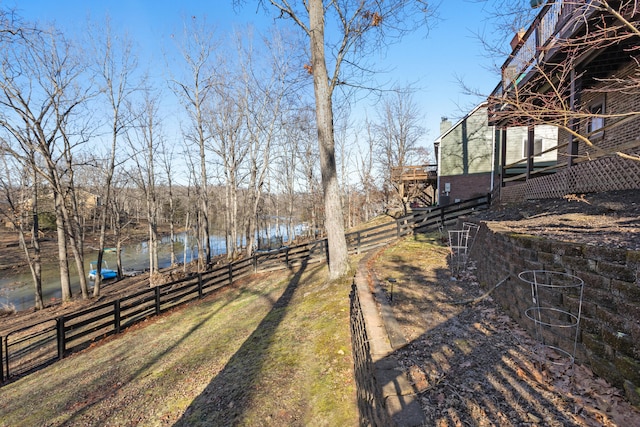 view of yard with a water view and fence