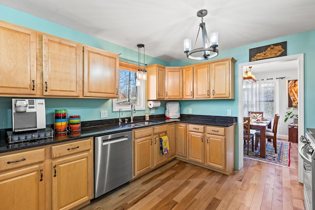 kitchen featuring light wood-style flooring, a sink, hanging light fixtures, appliances with stainless steel finishes, and an inviting chandelier