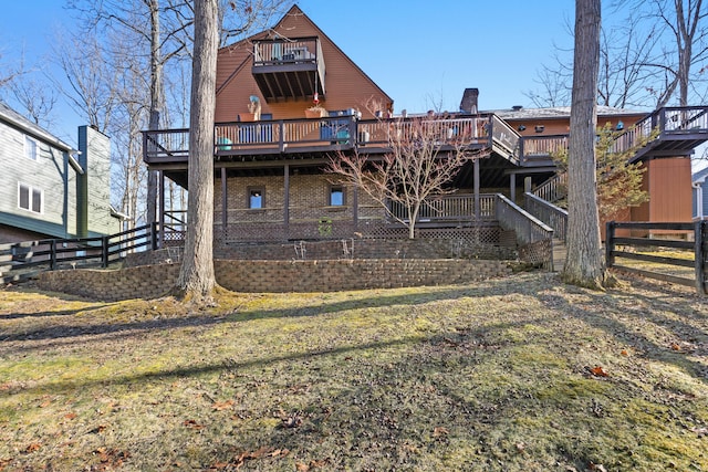 back of property featuring a yard, fence, and a wooden deck