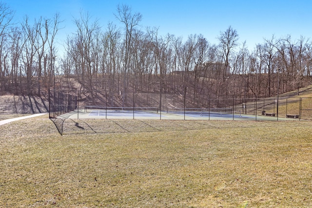 view of yard with a tennis court and fence