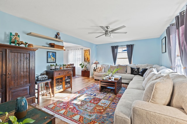 living area with a ceiling fan and wood finished floors