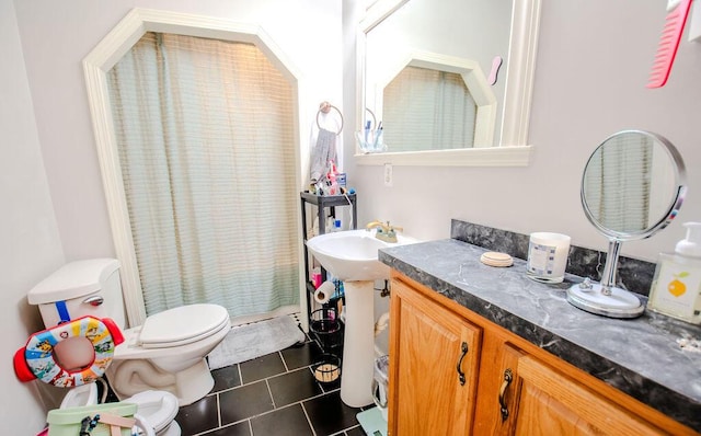 bathroom with tile patterned flooring, a shower with shower curtain, a sink, and toilet