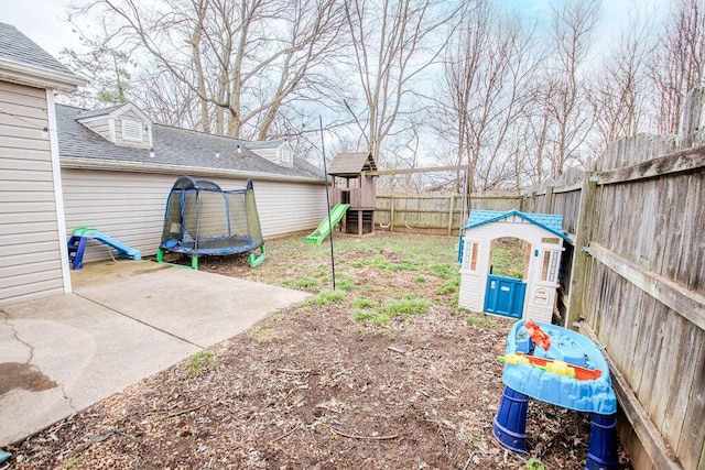 view of yard with a trampoline, a playground, a patio, and a fenced backyard