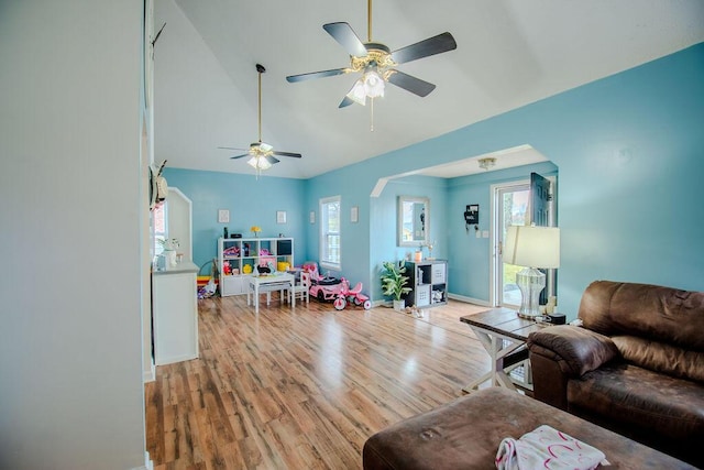 living room featuring vaulted ceiling, light wood-style flooring, and baseboards