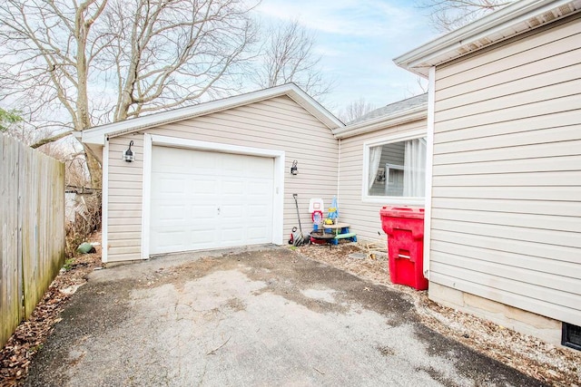 garage with driveway and fence