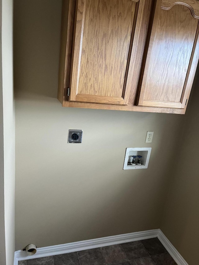 laundry room featuring hookup for a washing machine, cabinet space, hookup for an electric dryer, dark tile patterned flooring, and baseboards