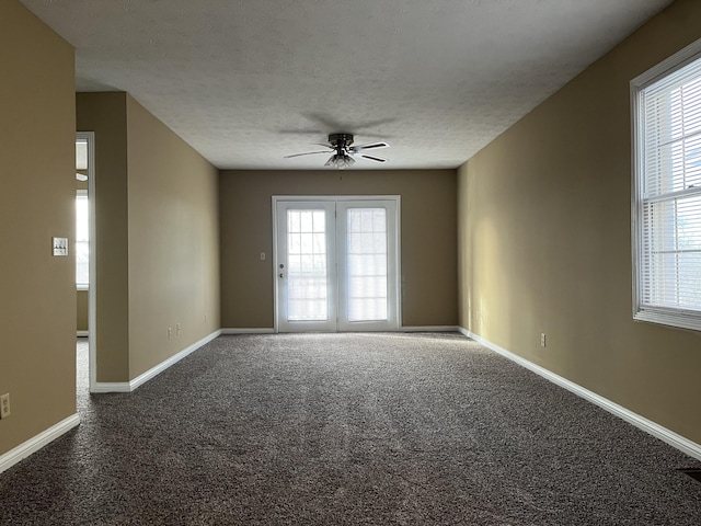 empty room featuring carpet flooring, ceiling fan, a textured ceiling, and baseboards