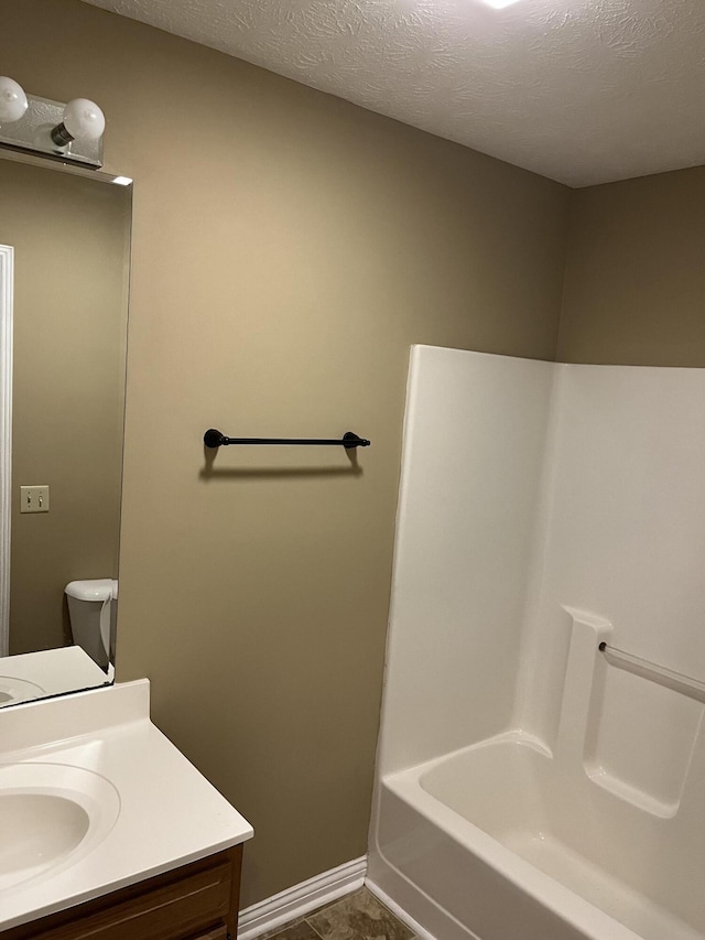 bathroom featuring a bathing tub, a textured ceiling, vanity, baseboards, and walk in shower