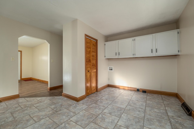 laundry room featuring arched walkways, washer hookup, cabinet space, visible vents, and baseboards