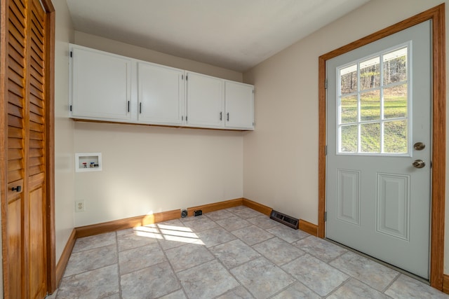 laundry room with stone finish flooring, hookup for a washing machine, cabinet space, and baseboards