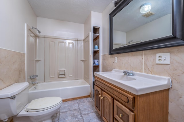 bathroom featuring tile walls, shower / bath combination, visible vents, toilet, and a textured ceiling