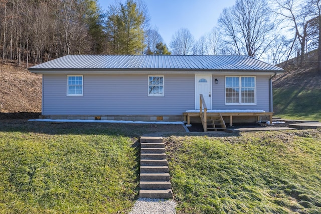 view of front of property with metal roof, a front lawn, and crawl space