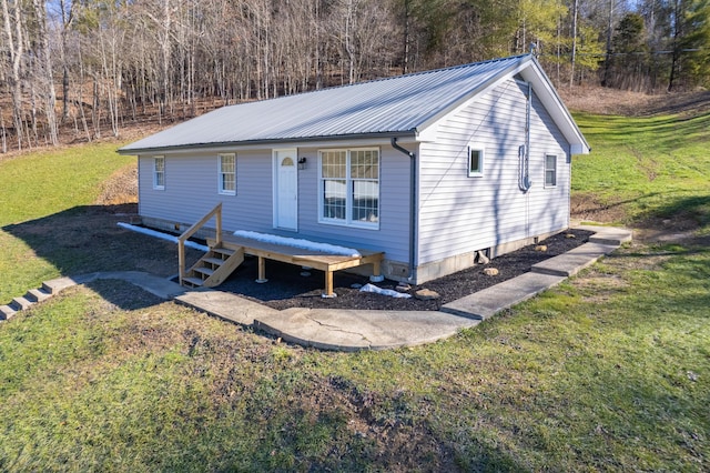 view of front of house with metal roof and a front lawn