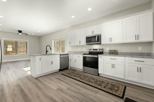 kitchen featuring stainless steel appliances, white cabinets, and a peninsula