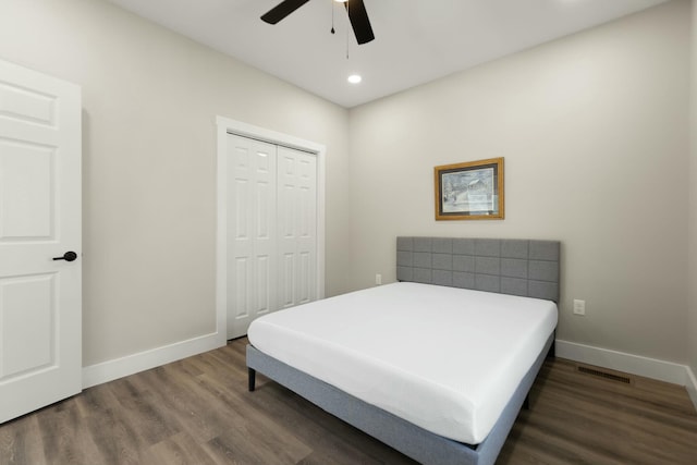 bedroom featuring visible vents, baseboards, ceiling fan, dark wood-style flooring, and a closet