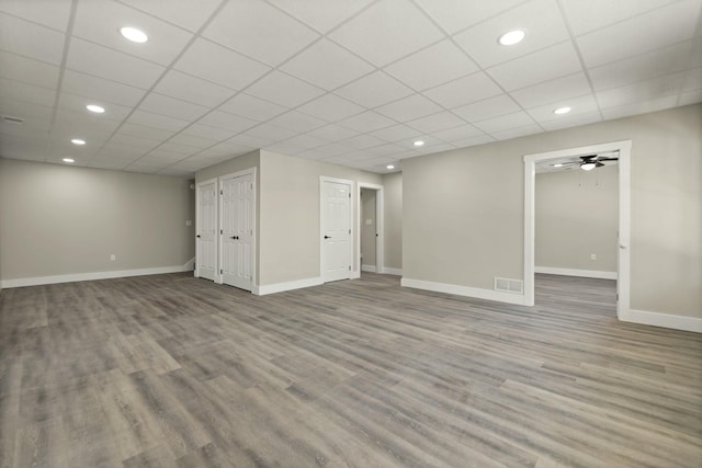 finished below grade area with visible vents, light wood-style flooring, and baseboards