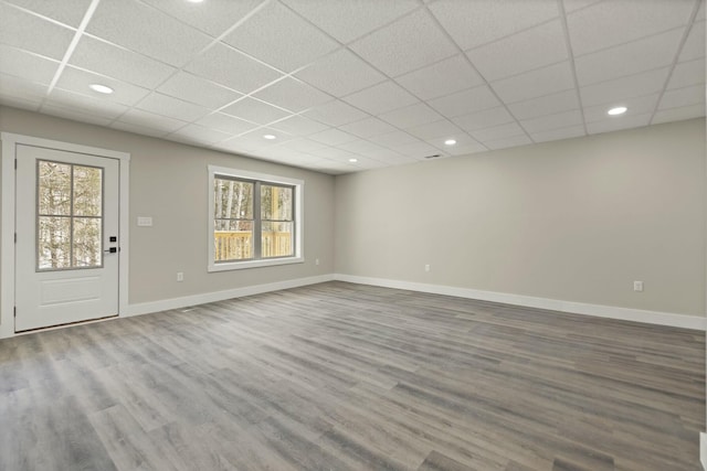 interior space with baseboards, a drop ceiling, wood finished floors, and recessed lighting