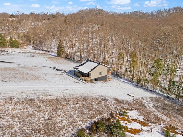 snowy aerial view with a wooded view