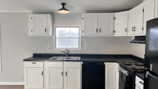 kitchen with dark countertops, black appliances, under cabinet range hood, and a sink