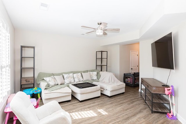 living area with ceiling fan, wood finished floors, and visible vents