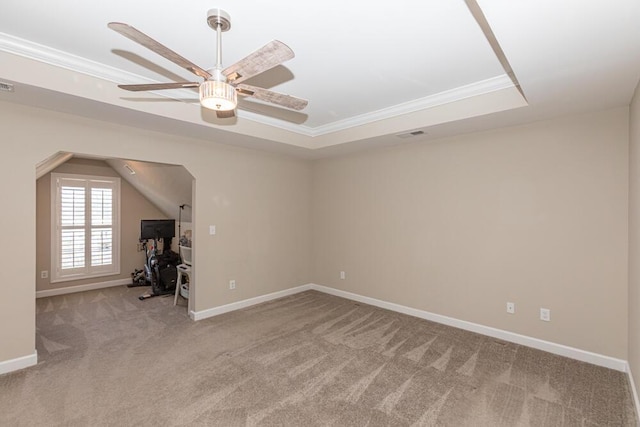 interior space with light carpet, visible vents, baseboards, ornamental molding, and a raised ceiling