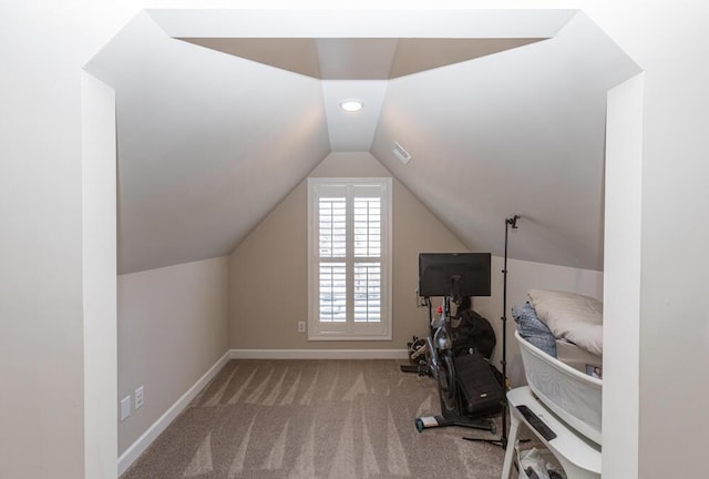 exercise room featuring vaulted ceiling, carpet floors, and baseboards