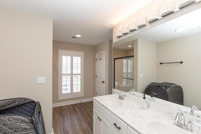 bathroom with visible vents, a sink, baseboards, and wood finished floors