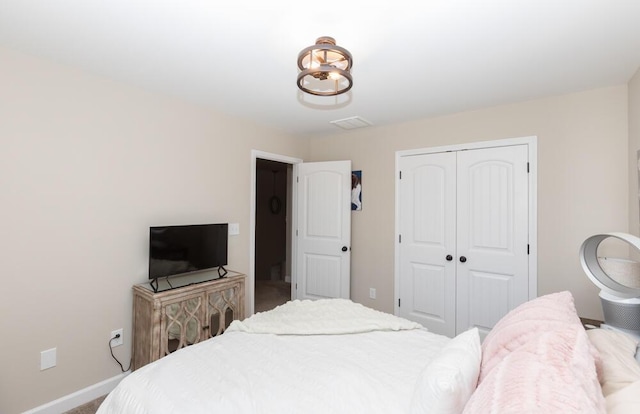 bedroom with carpet floors, visible vents, baseboards, and a closet